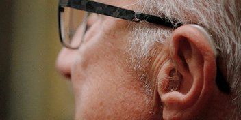 hombre con pérdida auditiva usando audífonos