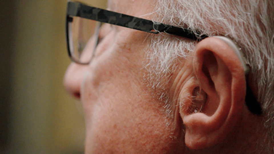 la imagen muestra un hombre con audífonos discretos