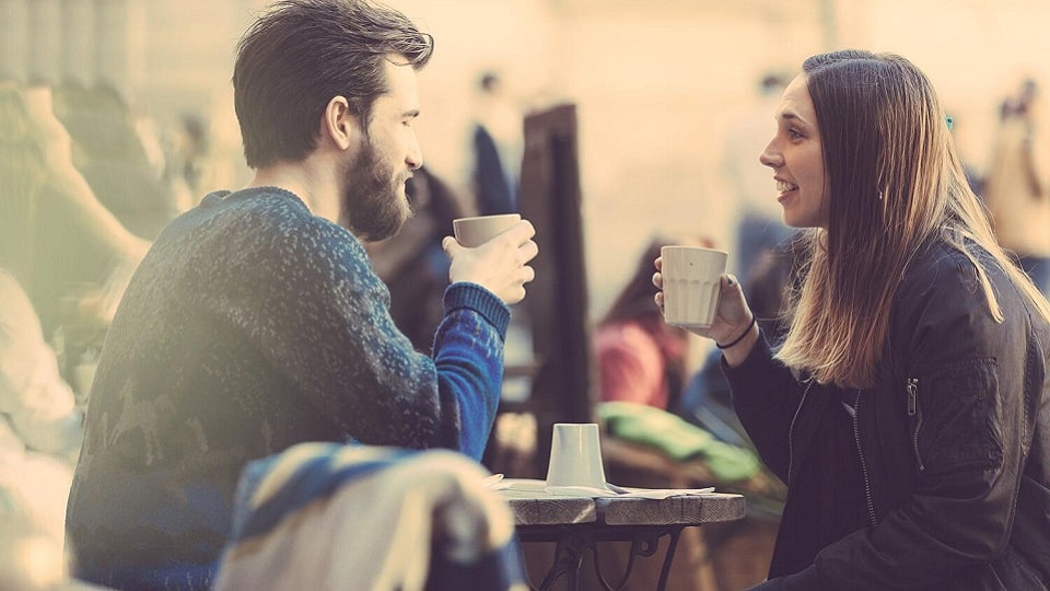Deux personnes discutant autour d'un café