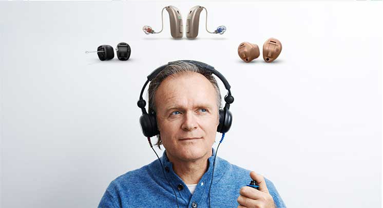 Un homme réalise un test auditif et plusieurs appareils auditifs sont affichés au dessus de sa tête