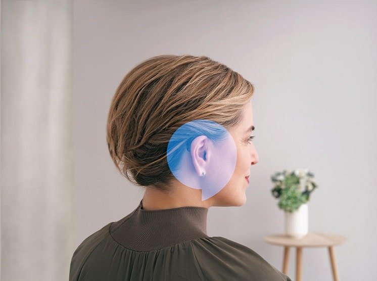 Une femme portant des appareils auditifs qui se fond dans les cheveux 