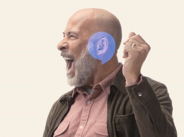 Un homme portant des appareils auditifs criant de joie 