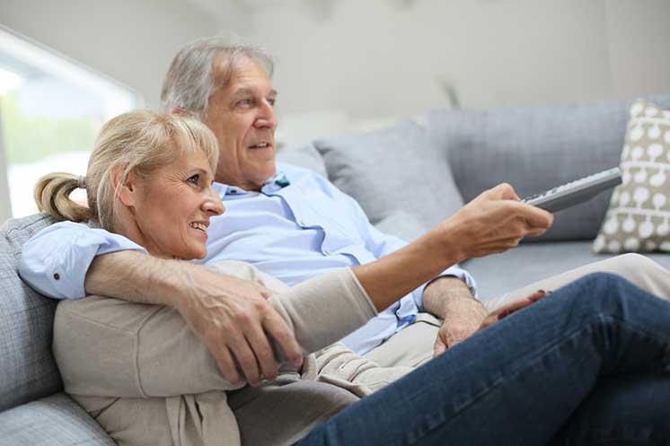 Un couple de personnes âgées regarde la télévision