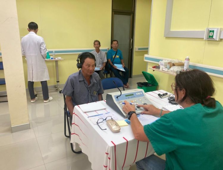 Un homme cambodgien est en train de réaliser un bilan auditif lors de la mission humanitaire d'Audika