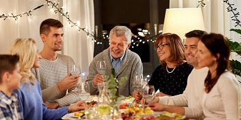 Une fête de famille avec des personnes qui discutent autour d'un repas 