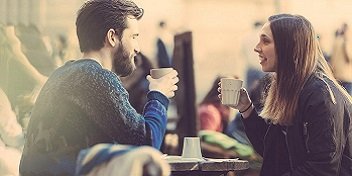 Deux personnes qui discutent autour d'un café