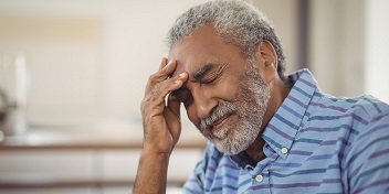 Homme avec tympan percé tenant sa tête avec sa main