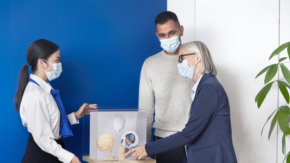 Personnes avec des masques sanitaires dans un centre auditif
