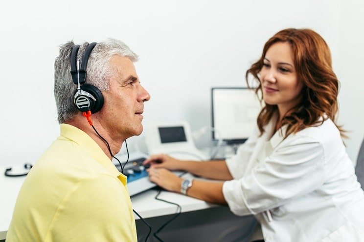Un homme réalise un bilan auditif avec un audioprothésiste