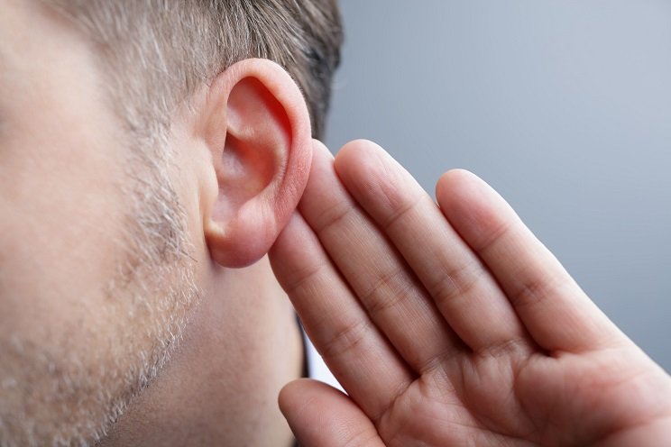 Homme qui tend l'oreille à cause d'une perte auditive