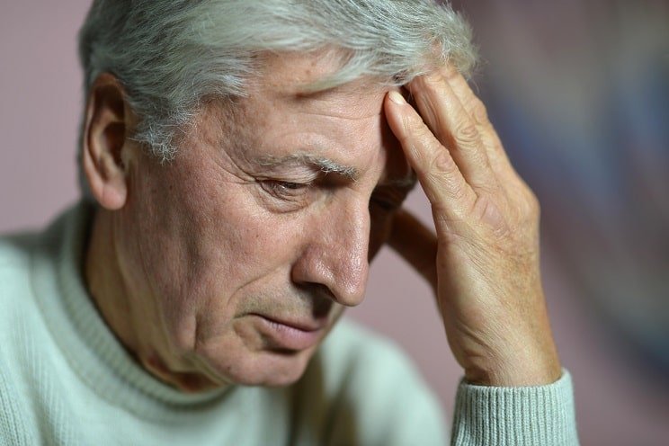 Homme souffrant d'acouphènes et de maux de tête suite à la presbyacousie