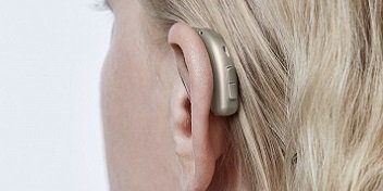 aide auditive placée sur le contour d'oreille d'une femme