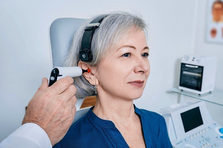 Kobieta wykonuje badanie słuchu (tympanometria) w gabinecie specjalisty.
