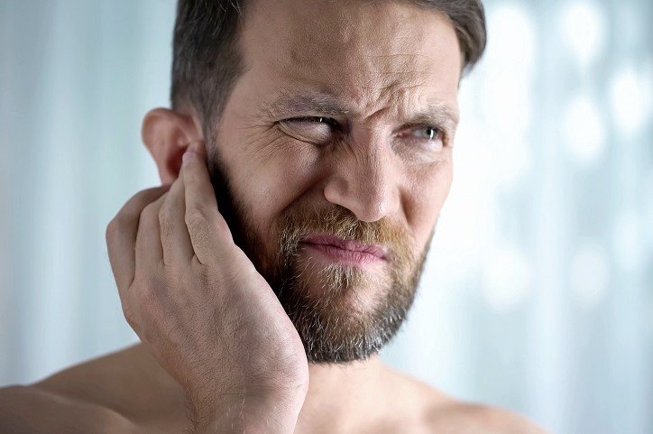 Mężczyzna zastanawia się, jak zapobiegać utracie słuchu i leczyć niedosłuch.