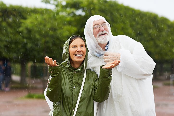Kobieta i mężczyzna słuchają deszczu w parku.