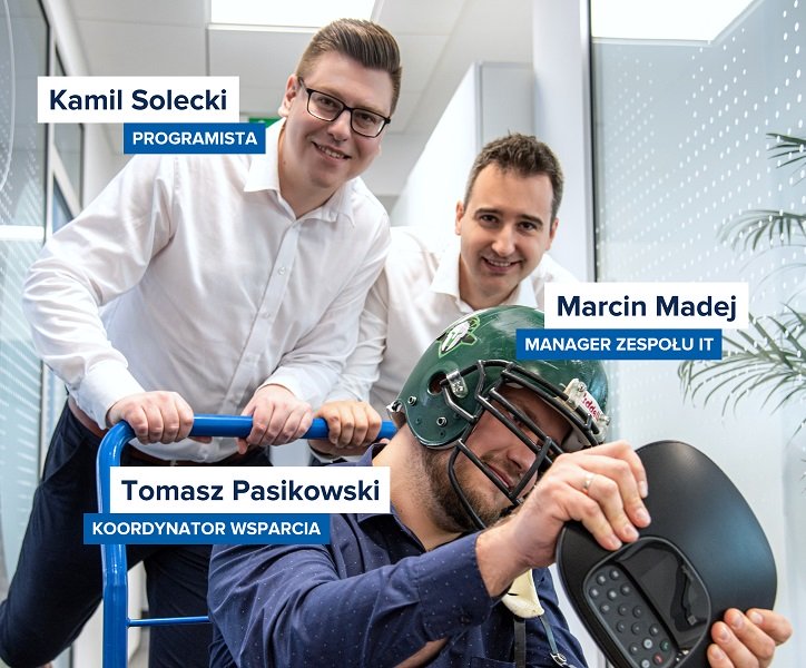 Kamil Solecki, Marcin Madej i Tomasz Pasikowski przemieszczają się po korytarzu na wózku dostawczym.