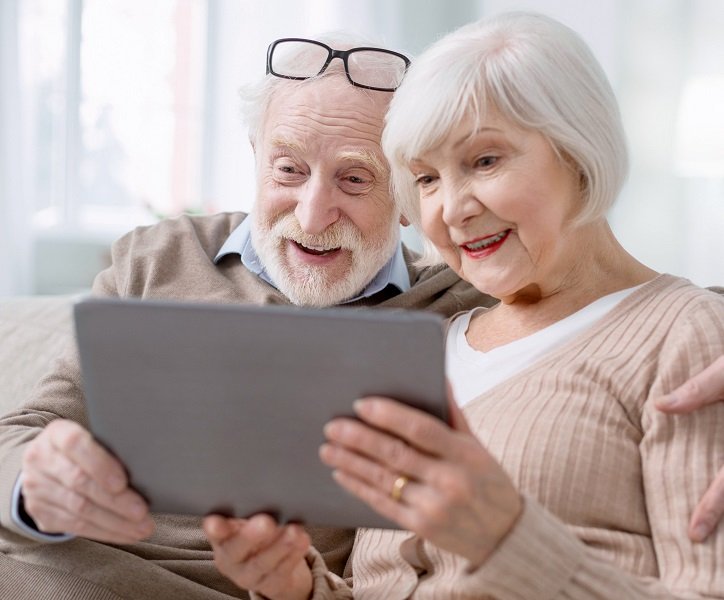 Kobieta i mężczyzna umawiają wizytę online w gabinecie protetyka słuchu.