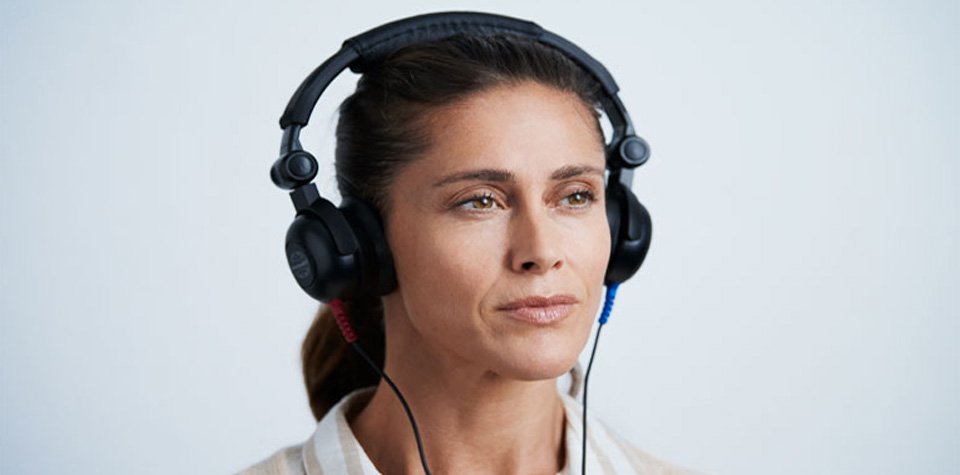 Bild på tjej som testar sin hörsel på Audikas hörseldag för att hitta  hörselnedsättning