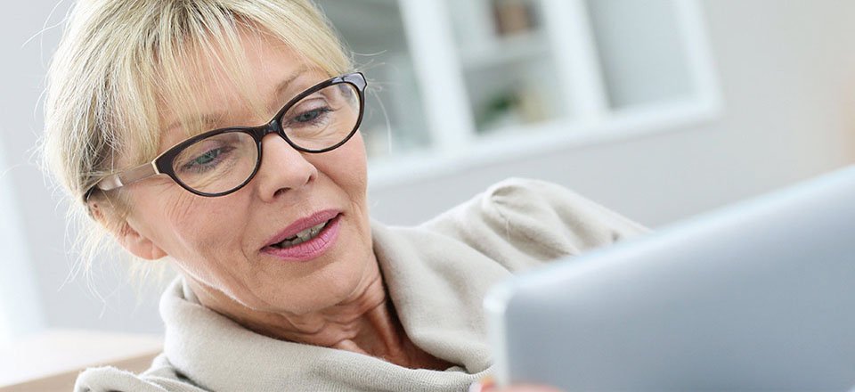 Bild på en kvinna som läser på om online hörseltest innan hon gör det