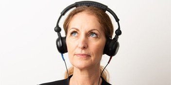 Bild på en kvinna som är på en hörseldag och gör ett snabbtest av sin hörsel hos Audika