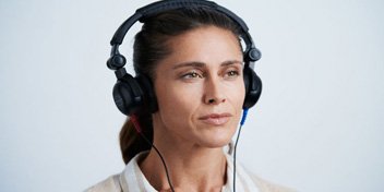 Bild på kvinna på Audikas hörseldag som testar hörsel för att hitta hörselnedsättning
