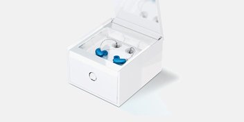 Bild på en hörapparatsbehållare med ett par blå hörapparater