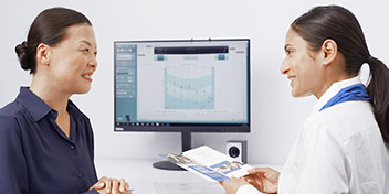 Bild på audionom och patient framför dator