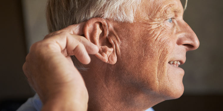 Bild på en man som älskar sina hörapparater och har tagit en del av Audikas kunderbjudande