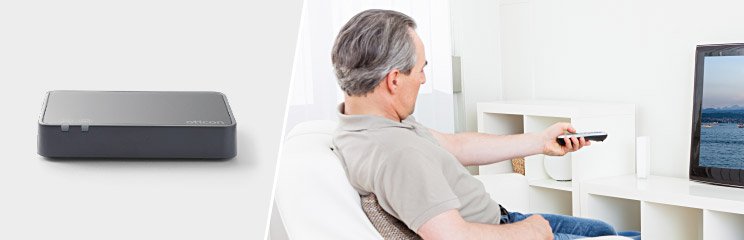 Bild på hörselhjälpmedel tv-adapter och en man som sitter framför en tv
