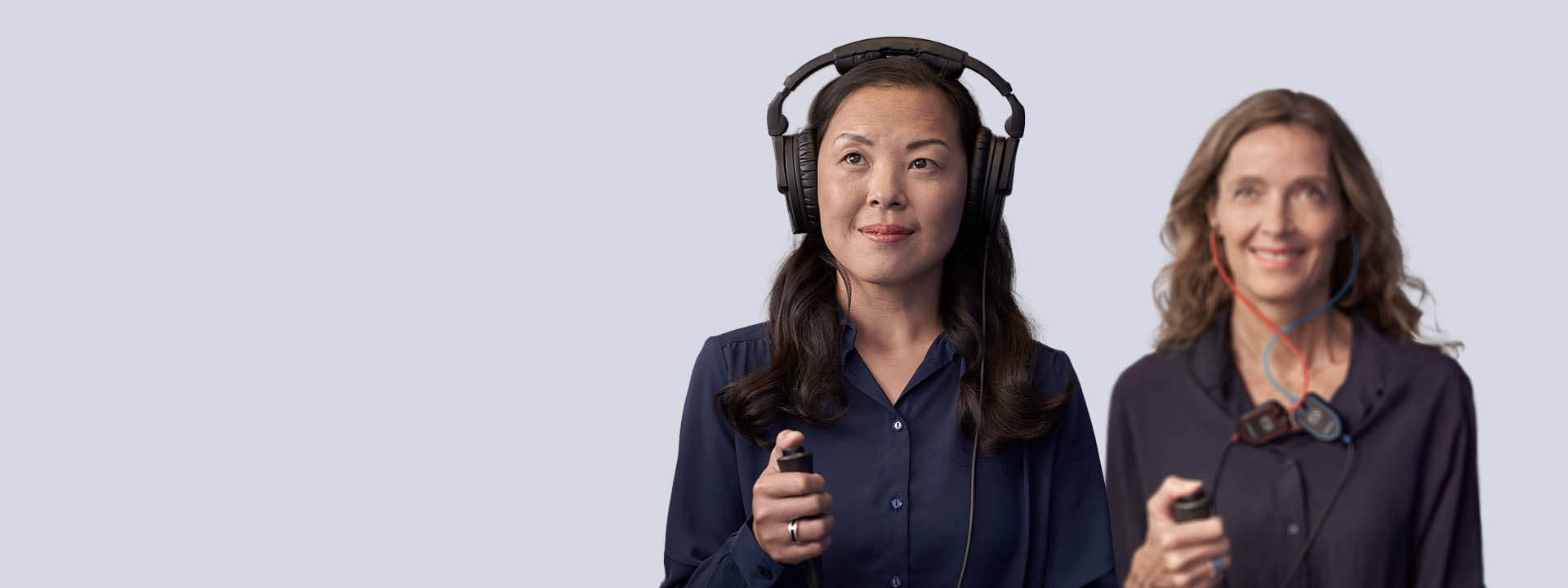 Bild på kvinnor med hörlurar och gör hörseltest i Stockholm.