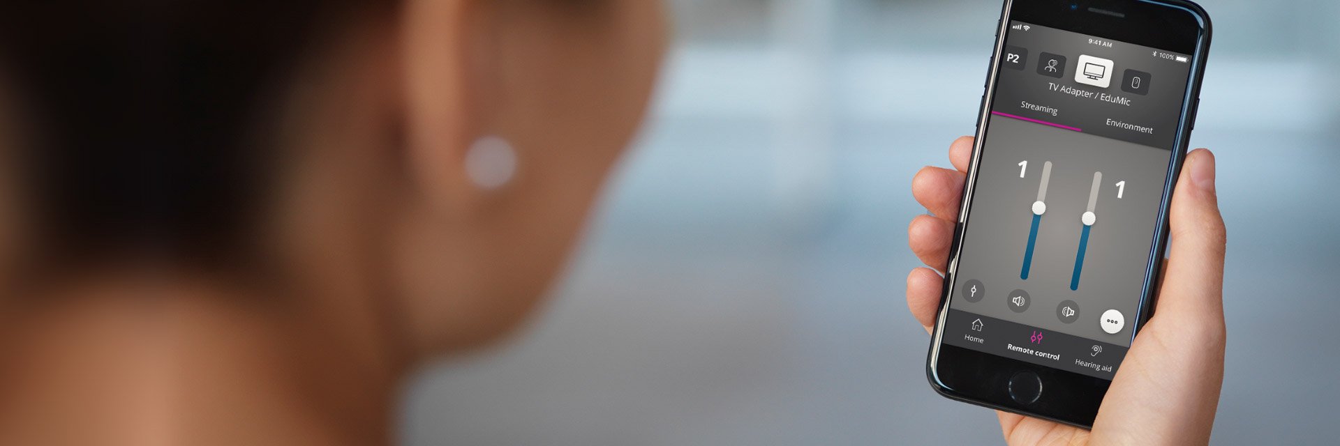 Bild på en kvinna som justerar volym i oticon on appen som är ett hörselhjälpmedel