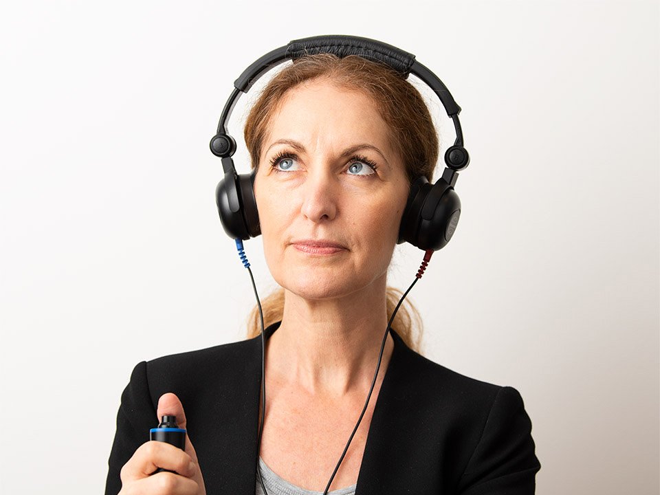 Bild på en kvinna som är på en av Audikas hörseldagar och gör ett gratis snabbtest av sin hörsel