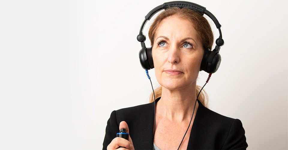 Bild på en kvinna som testar sin hörsel efter att ha bokat ett hörseltest
