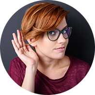 Bild på en kvinna med handen nära örat som visar att hon lyssnar.
