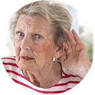 Bild på äldre kvinna som har handen bakom örat för att höra mummel på grund av hörselnedsättning på höga frekvenser