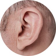 Bild på ett örat som har en minirite hörapparat på sig