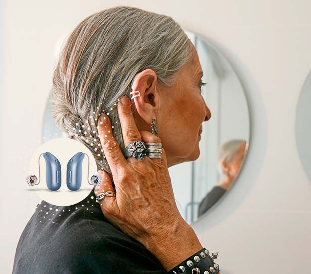 Bild på en kvinna som har en Oticon Intent hörapparat på dig, som kan kopplas till flera olika hörselhjälpmedel