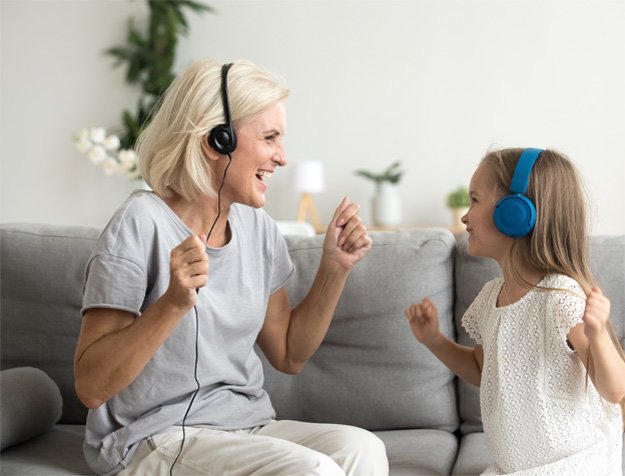 Bild på en kvinna och ett barn som använder hörselskydd för att förbygga nedsatt hörsel