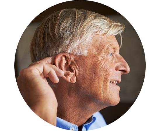 Bild på man som har en avancerad hörapparat bakom örat.