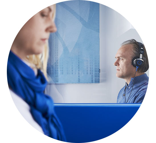 En audionom hjälper en man med hörlurar att göra ett hörseltest i Stockholm.