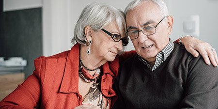 Image show older couple sitting close together