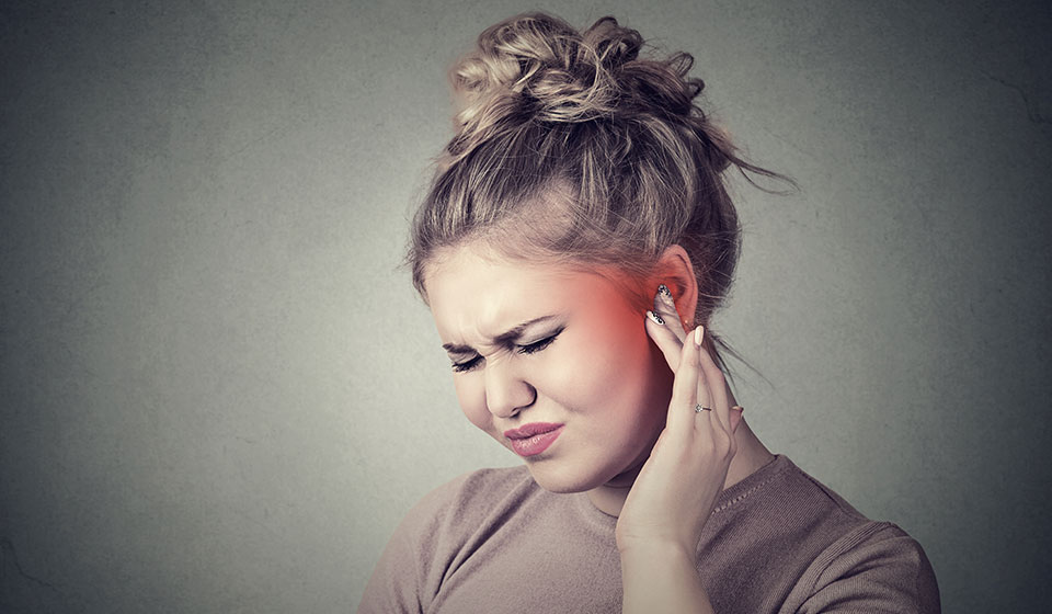 woman holding ear in pain teeth grinding 
