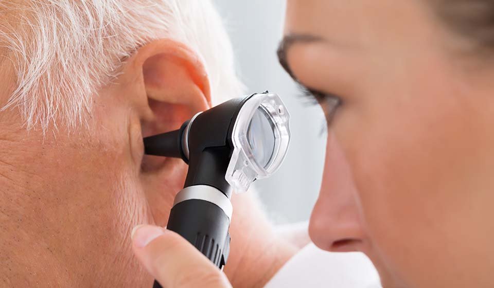 audiologist checking inside ear