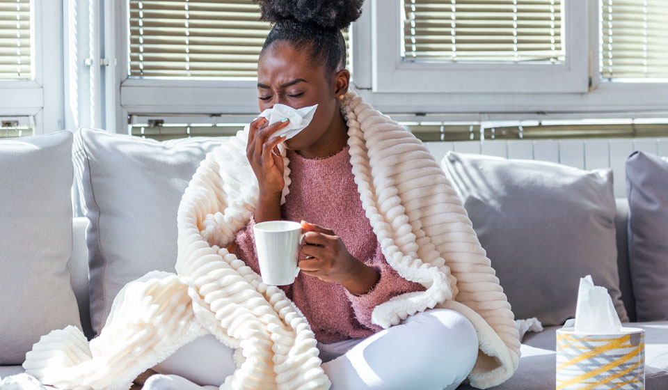 Images shows a lady who is sick with a cold