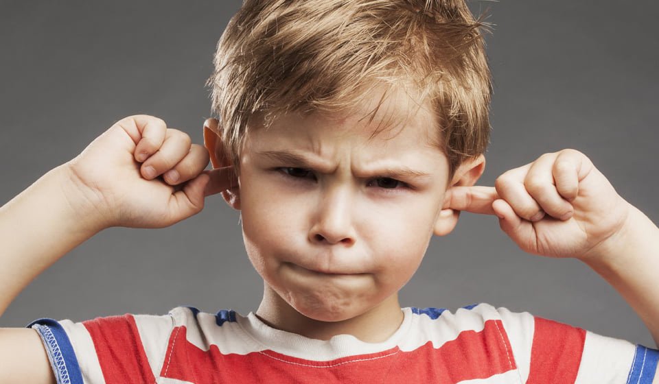 Images shows a child with fingers in his ears