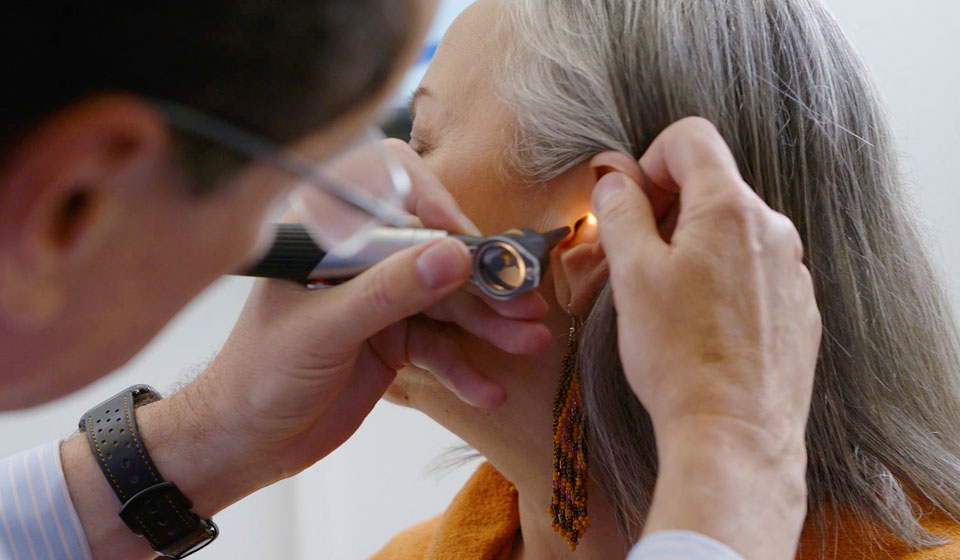 Images shows a lady getting her ear checked