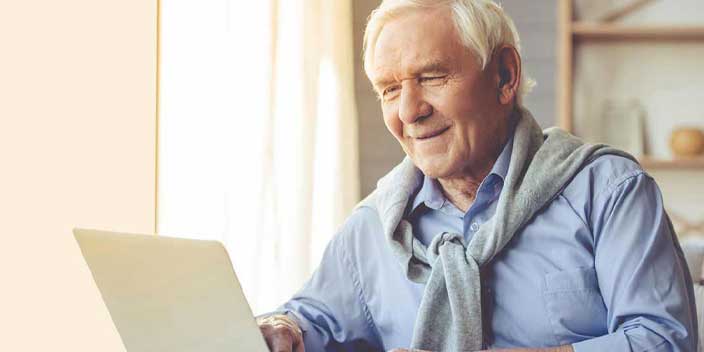 Image shows a man using a laptop