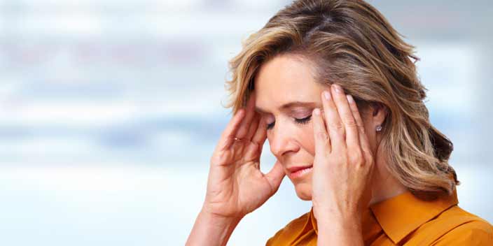 Image shows a woman suffering from tinnitus