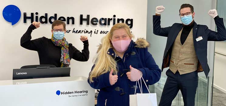 One of our CFBH ambassadors celebrates receiving her new hearing aids with her dispenser and branch coordinator