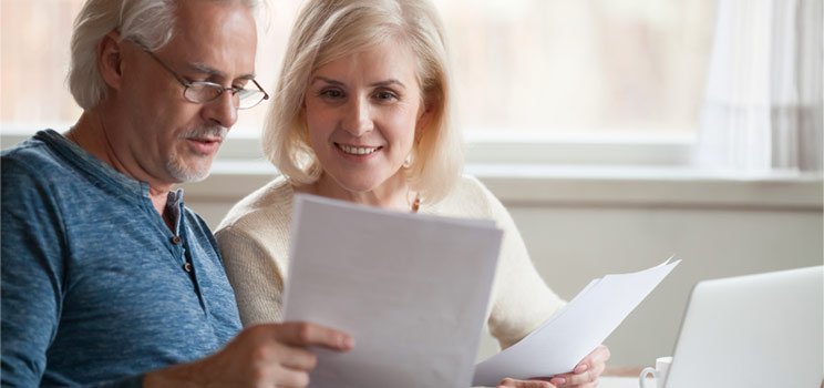 Image shows a couple discussing hearing aid insurance 